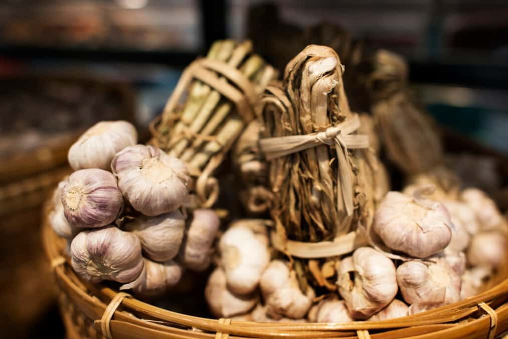 Garlic bulbs tied in bundles displayed in a basket